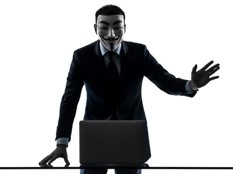 PARIS– OCTOBER 30 : one man dressed and masked as a  member of Anonymous underground group member computing computer  saluting on October 30, 2012 in Paris ,France