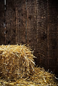 Bale of straw and dark wooden background with vignette