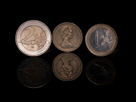 Pound and Euro coins on Black