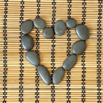 Details of a tranquil scene, made ??of black pebbles in a heart.