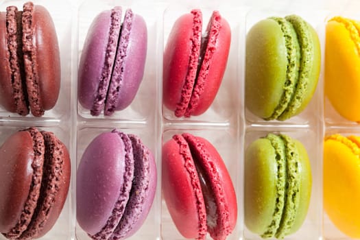 Close-up of assortment of colorful macaroons in tray on light background