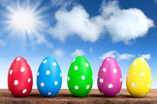 colorful easter eggs in the garden with blue sky