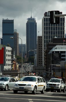 city traffic in sydney, taxi and police car in front, skyscrapers in background