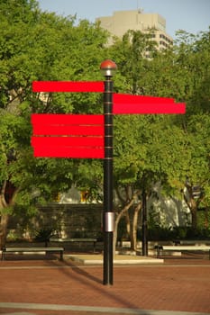 several red empty city signs, trees in background