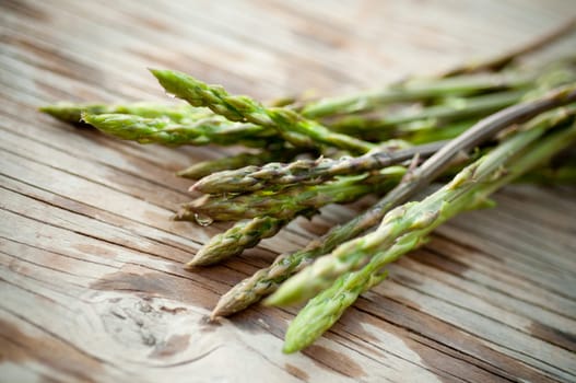 Wild asparagus on wooden surface