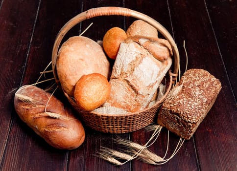 Delicious bread in basket on wooden table