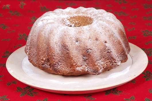 Christmas cake on wooden plate. Red background.