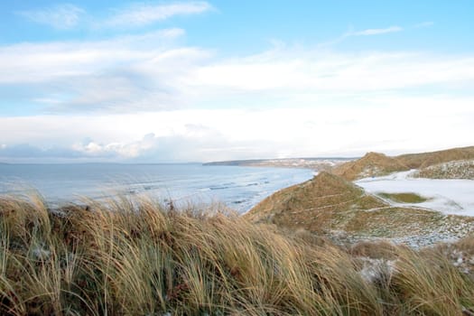 atlantic ocean beside a snow covered links golf course in ireland in snowy winter weather