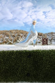 a crystal glass slipper on a hole marker sign in a snow covered irish golf course for a concept on ladies golf