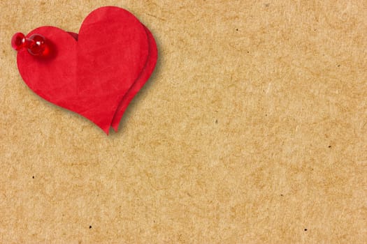 Two red paper hearts pinned to the  cardboard