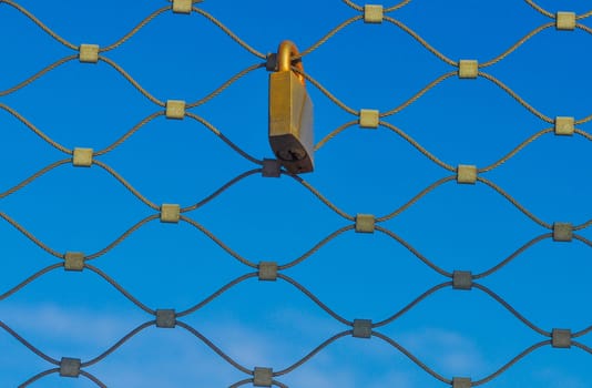 Padlock on a metal grid net fence