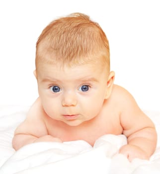 Baby boy unclothed on white sheet, studio portrait.