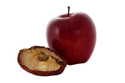 A fresh apple and a dried quarter of an apple in front