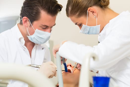 Female patient with dentist and dental assistant during treatment