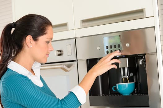 Happy young woman making coffee cup machine kitchen interior