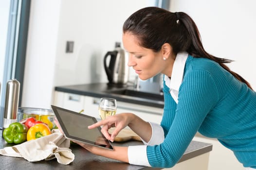 Young woman reading recipe tablet searching kitchen preparing vegetables