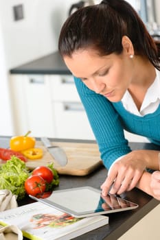 Young woman looking tablet recipe kitchen vegetables preparing food