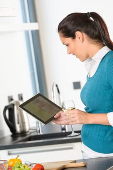 Happy woman looking recipe tablet kitchen reading cooking