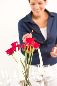 Young woman lighting candle lunch romantic love red roses