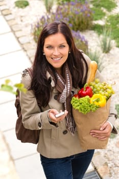 Happy woman shopping phone groceries texting vegetables mobile bag