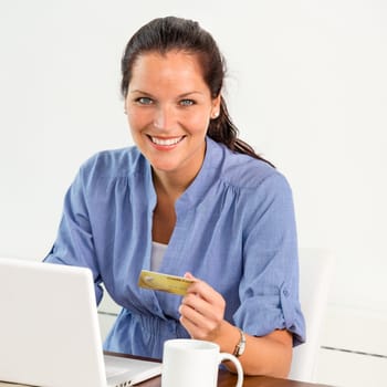 Smiling woman paying bills online banking home credit card consumerism