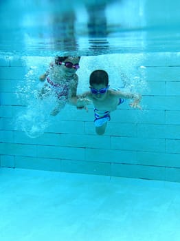 Girl and boy diving and having fun underwater