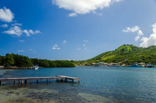 Wooden dock with tropical island in background in San Andres y Providencia, Colombia