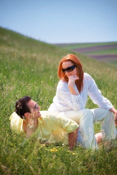 Conceptual image with woman sitting on the man, portrait outdoor.