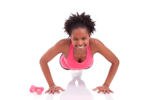 Young beautiful african fitness woman doing push up exercises on floor,isolated on white background