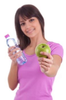Young caucasian woman holding a bottle of water and an apple over white background