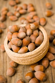Hazelnuts in pot on wooden surface