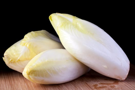 Fresh raw chicory with dark background.