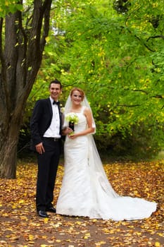 Newly wed couple outdoor in the park in fall.