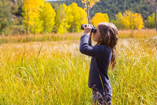 Explorer binocuar looking kid girl in yellow autumn nature outdoor