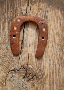 Antique horseshoe luck symbol rusted on vintage wood background