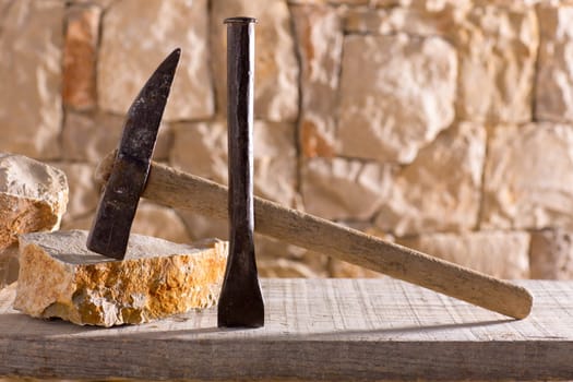 Hammer mason tools of stonecutter masonry work in a contruction stone wall