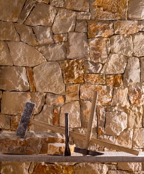 Hammer mason tools of stonecutter masonry work in a contruction stone wall
