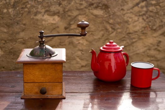 retro old coffee grinder with vintage teapot and red cup