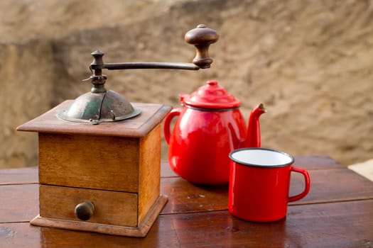 retro old coffee grinder with vintage teapot and red cup