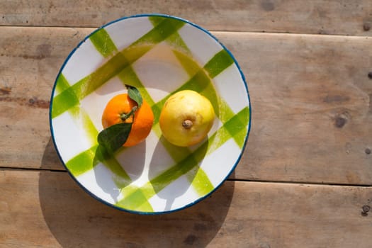 fruits tangerine and pear in vintage porcelain dish plate on retro wood table