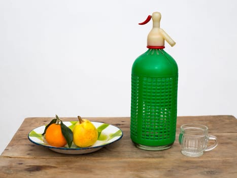 fruits tangerine and pear in vintage porcelain dish with retro soda bottle