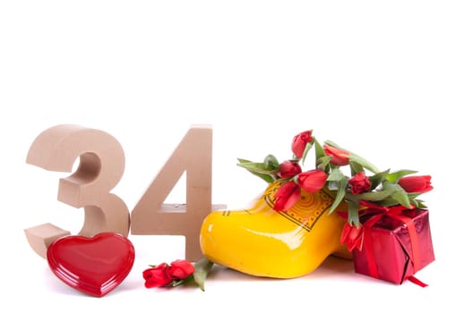 Number of age in a colorful studio setting and Dutch looking attributes like a clog woonden shoe and tulips