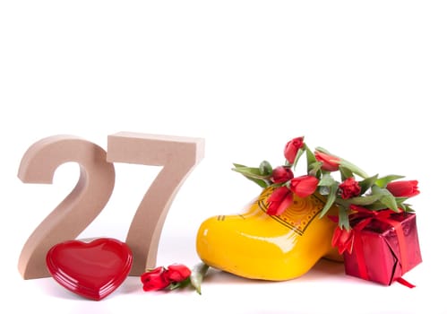 Number of age in a colorful studio setting and Dutch looking attributes like a clog woonden shoe and tulips