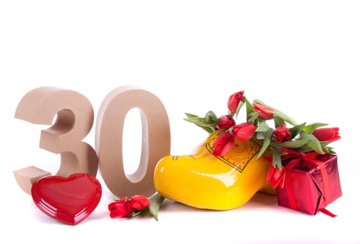 Number of age in a colorful studio setting and Dutch looking attributes like a clog woonden shoe and tulips