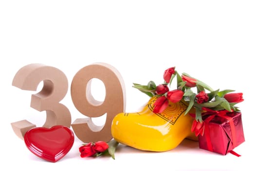 Number of age in a colorful studio setting and Dutch looking attributes like a clog woonden shoe and tulips