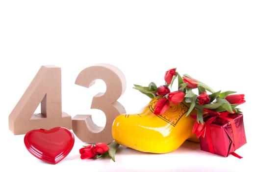 Number of age in a colorful studio setting and Dutch looking attributes like a clog woonden shoe and tulips