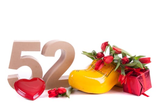 Number of age in a colorful studio setting and Dutch looking attributes like a clog woonden shoe and tulips