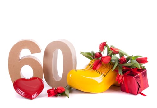 Number of age in a colorful studio setting and Dutch looking attributes like a clog woonden shoe and tulips