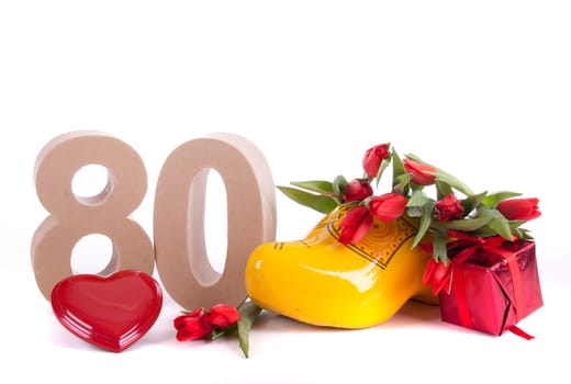 Number of age in a colorful studio setting and Dutch looking attributes like a clog woonden shoe and tulips