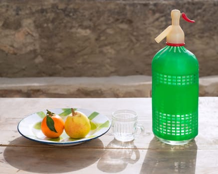 fruits tangerine and pear in vintage porcelain dish with retro soda bottle